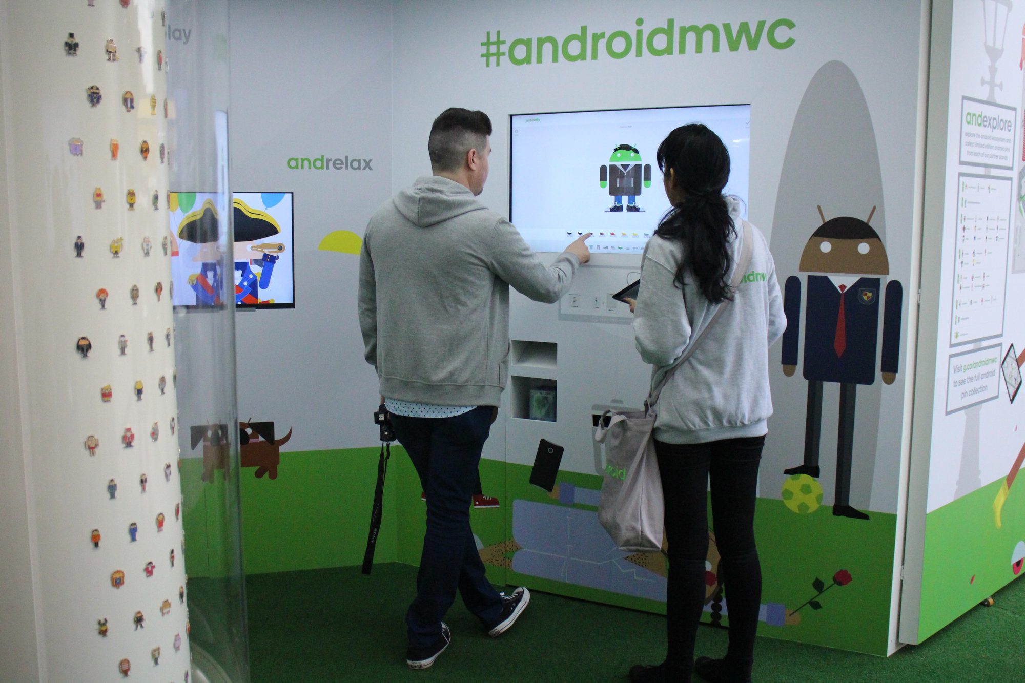 Guests designing avatars at a touchscreen inside the dome, a wall of printed stickers beside them