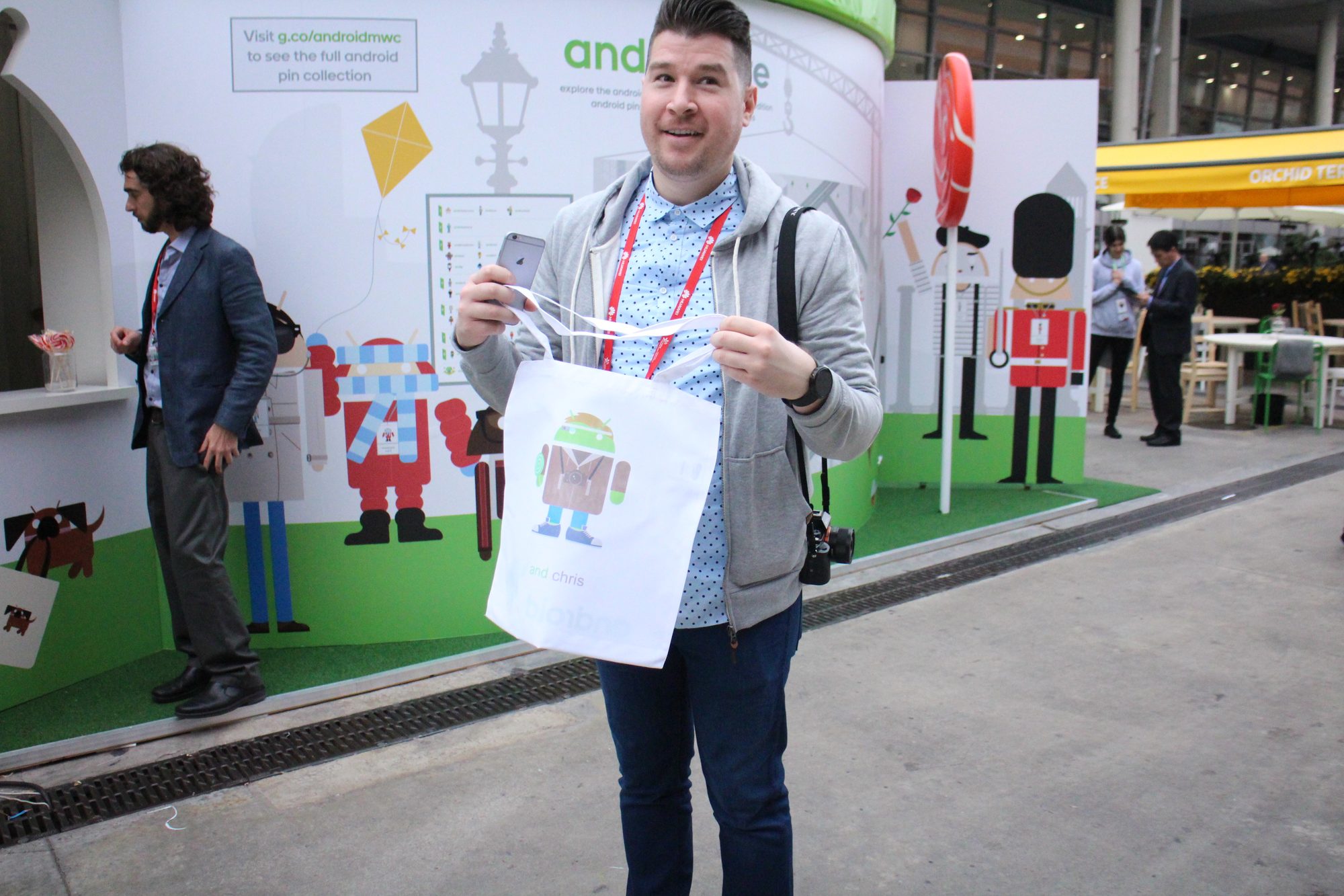A grinning delegate holding up his personalised Android avatar print