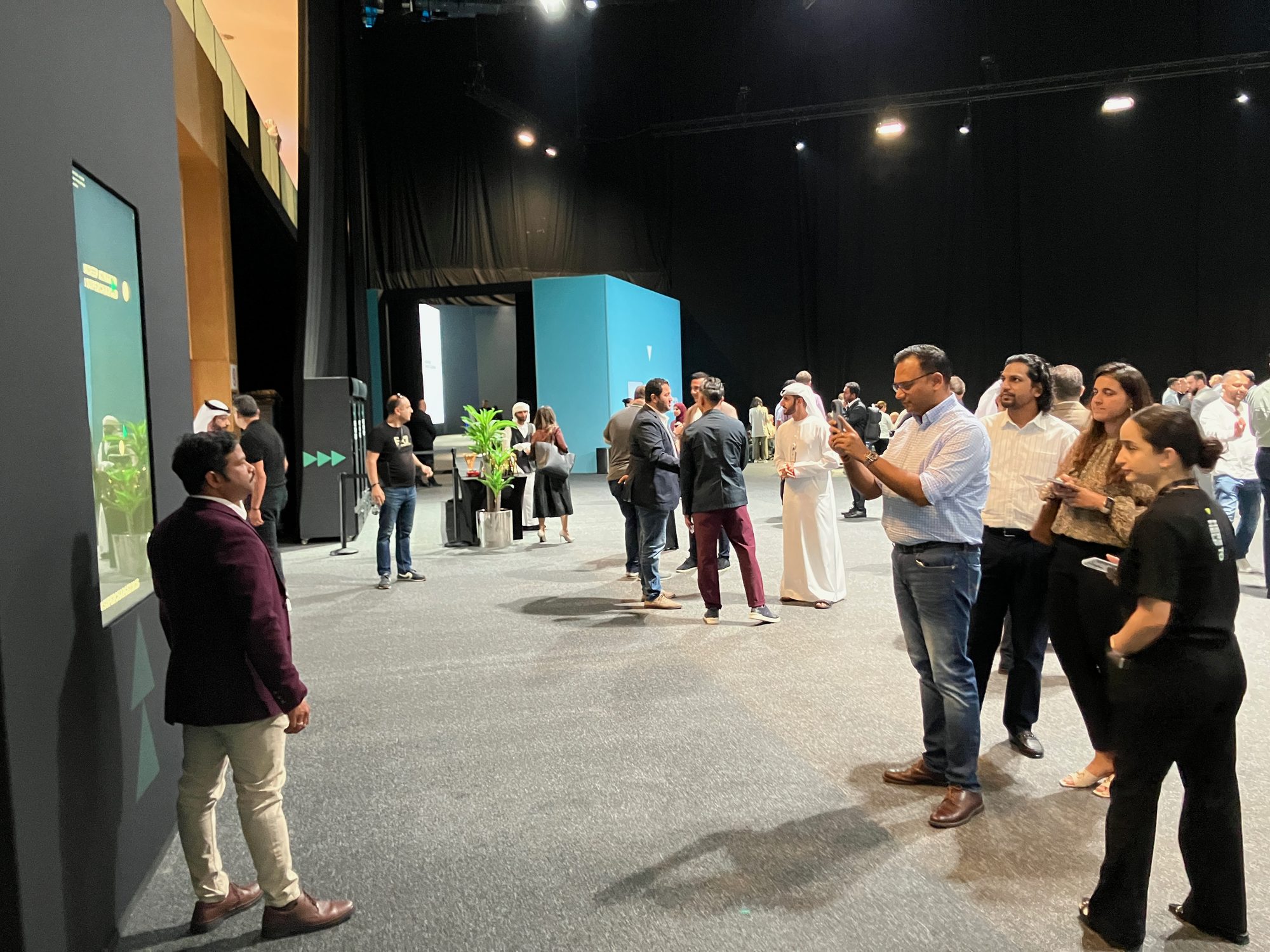 Guests gathered around a vertical activation screen in the exhibition hall